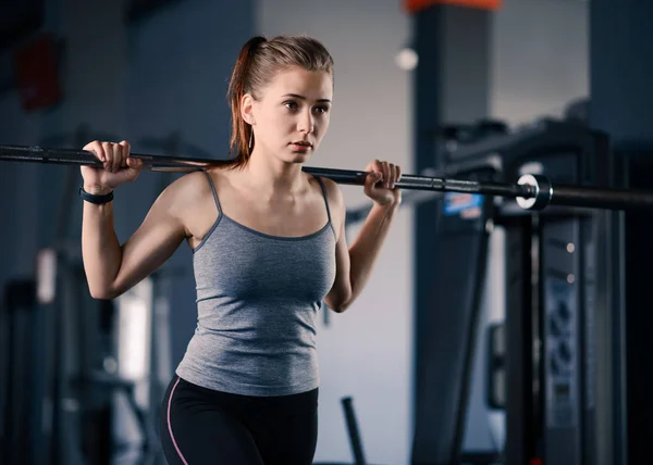 Jeune femme sportive séduisante faisant des bonds avec Barbell dans la salle de gym. Fitness et mode de vie sain . — Photo