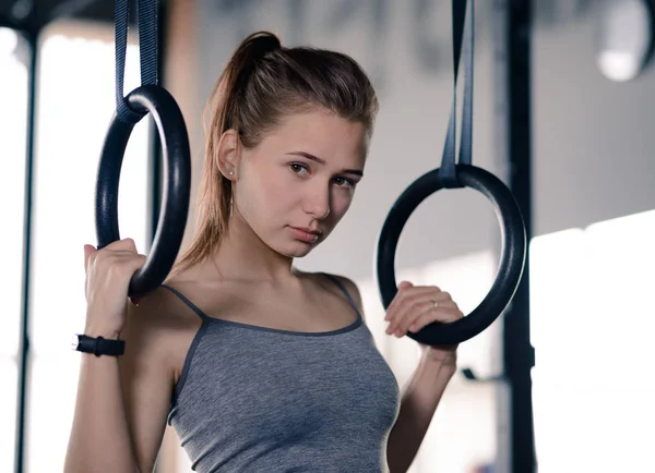 Portrait d'entraînement de femme sportive avec anneaux de gymnastique dans le gymnase. Concept de conditionnement physique et mode de vie sain . — Photo