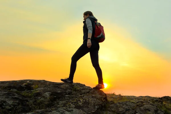 Young Woman Traveler Hiking with Backpack on the Rocky Trail at Warm Summer Sunset. Travel and Adventure Concept. — Stock Photo, Image