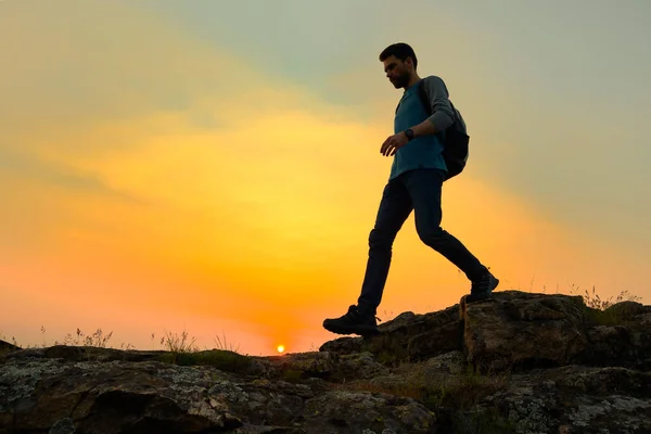 Young Happy Man Traveler Hiking with Backpack on the Rocky Trail at Warm Summer Sunset. Travel and Adventure Concept. — Stock Photo, Image