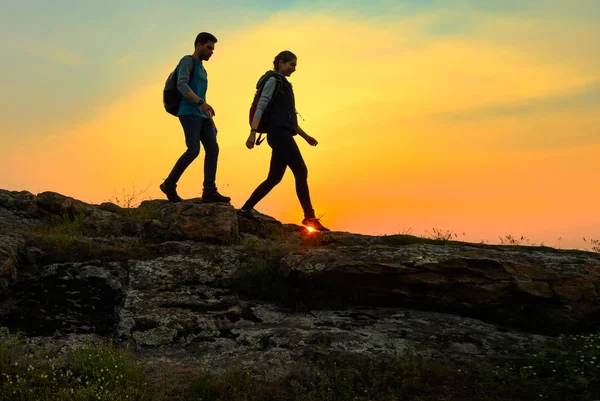 Young Happy Travelers Hiking with Backpacks on the Rocky Trail at Summer Sunset. Family Travel and Adventure Concept. — Stock Photo, Image