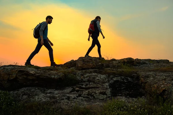 Couple Young Travelers Backpacks Walking Top Rock Warm Summer Sunset — Stock Photo, Image