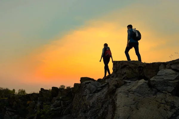 Couple Young Travelers Backpacks Walking Top Rock Warm Summer Sunset — Stock Photo, Image