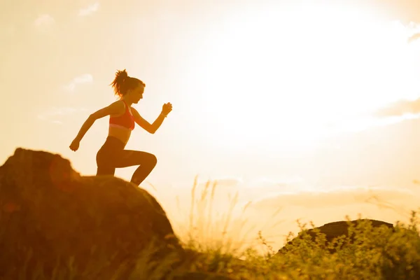 Ung vacker kvinna som springer på fjäll stigen vid varm sommar solnedgång. Idrott och aktiv livsstil. — Stockfoto