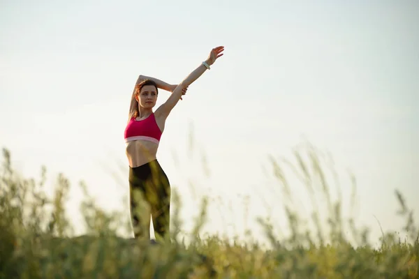 妇女做伸展户外。夏季晚上热身锻炼。运动与健康活跃生活理念. — 图库照片