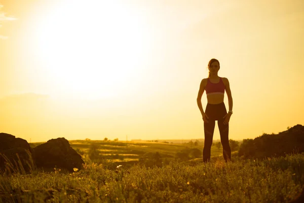 Γυναίκα κάνει τέντωμα εξωτερική. Προθέρμανση για άσκηση κατά του ηλιοβασιλέματος. Αθλητισμός και υγιής ενεργός σωτηρία. — Φωτογραφία Αρχείου