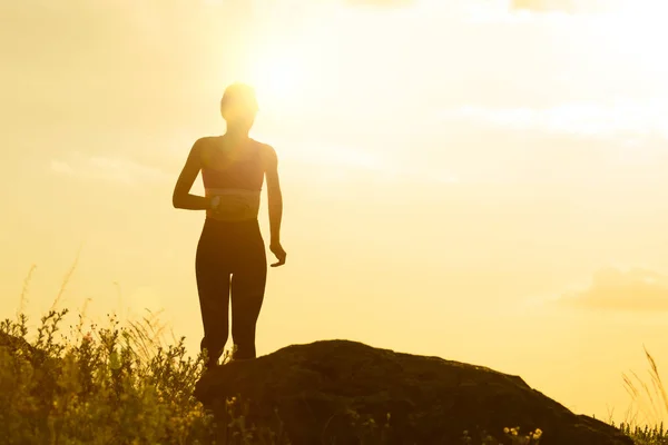 Fiatal gyönyörű nő fut a Mountain Trail a Hot Summer Sunset. Sport és aktív életmód. — Stock Fotó