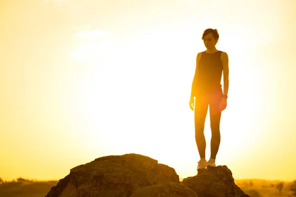 年轻女子站在岩石上对炎热美丽的夏日日落 冒险与健康活跃生活理念 — 图库照片