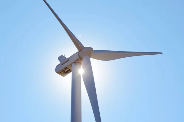 Turbina Generadora de Viento en Luz de Sol Brillante en el Bacground de Cielo Azul. Concepto de Energía Renovable Verde . — Foto de Stock