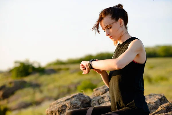 Jonge vrouw runner met behulp van multisport SmartWatch bij Sunset Trail. Close-up van hand met fitness tracker. Sport concept. — Stockfoto