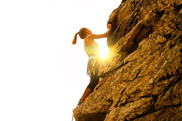 Hermosa mujer escalando en la roca en Foggy Sunset en las montañas. Aventura y concepto de deporte extremo — Foto de Stock