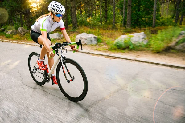 Young Woman Cyclist Riding Road Bicycle on the Free Road in the Forest at Hot Summer Day. Healthy Lifestyle Concept. — Stock Photo, Image