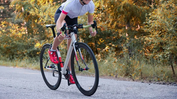 Giovane ciclista ciclista su strada Bicicletta sulla strada libera nella foresta a Hot Summer Day. Concetto di stile di vita sano . — Foto Stock