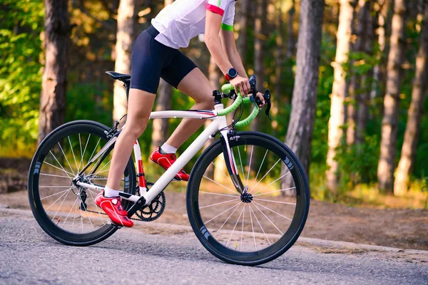 Jovem mulher ciclista equitação estrada bicicleta na estrada livre na floresta no dia quente de verão. Conceito de Estilo de Vida Saudável . — Fotografia de Stock