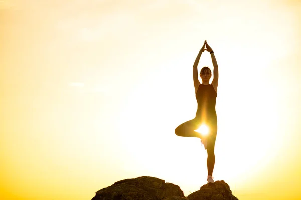 Mujer haciendo yoga al aire libre. Calienta el ejercicio contra la puesta del sol. Deporte y saludable activo Lifesyle Concept . —  Fotos de Stock