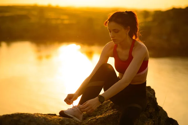 Mulher Esportiva Jovem Amarrando Sapatos de Corrida e Preparando-se para Corrida Trilha no Pôr do Sol. Estilo de vida saudável e conceito de esporte . — Fotografia de Stock