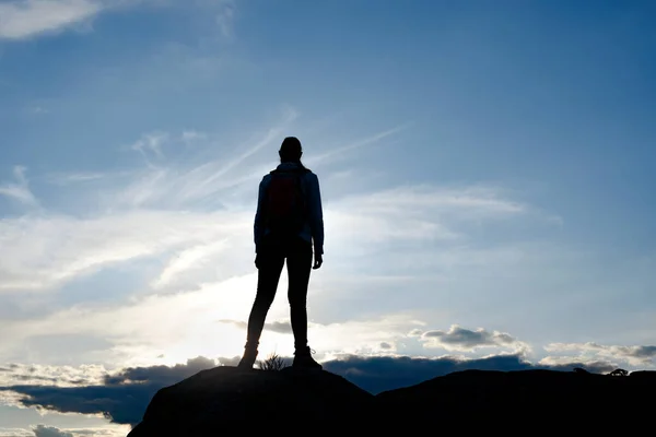 Молодая женщина-путешественница с рюкзаком, стоящим на вершине скалы на Летнем закате. Концепция путешествия и приключений. — стоковое фото
