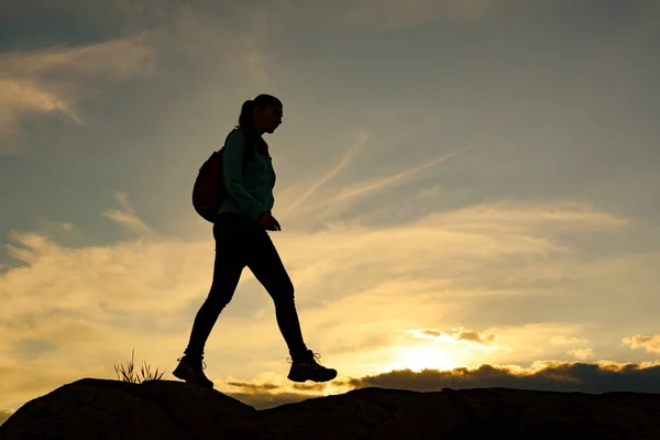 Joven viajera Senderismo con mochila en el hermoso sendero rocoso al atardecer de verano. Concepto de viaje y aventura . —  Fotos de Stock