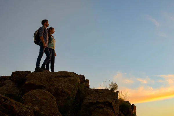 Couple of Young Travelers Standing on the Top of the Rock at Summer Sunset. Family Travel and Adventure Concept — Stock Photo, Image