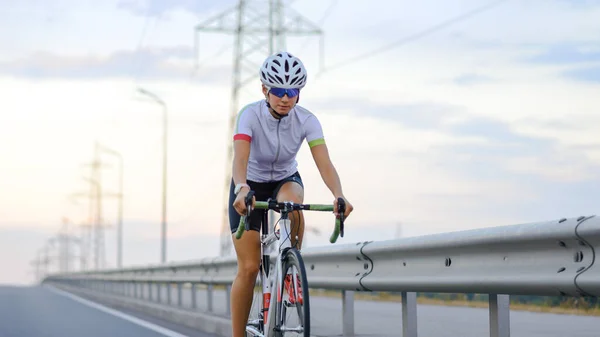 Молодая женщина велосипедистка Езда на велосипеде в вечернее время. Здоровый образ жизни, спорт — стоковое фото