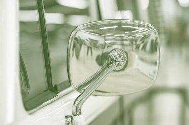 Bulanık bir arka planda geçmişe dönük bir araba. Ayrıntı: Dikiz aynası. Yumuşak odaklı Duotone