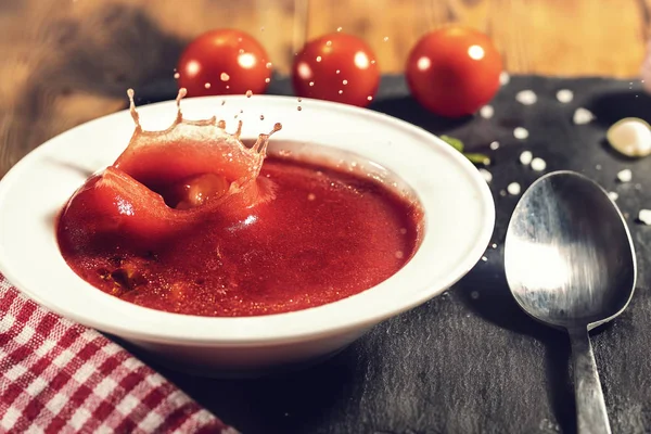 Gros plan d'une assiette de soupe gaspacho avec des tranches de tomate, concombre et oignon, avec des feuilles de persil — Photo