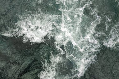 Su akışı ve bir taştan fışkırma. Yakından.