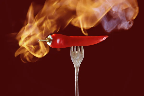 Chili peppar röd eld, brinnande peppar, peppar, på en röd bakgrund — Stockfoto