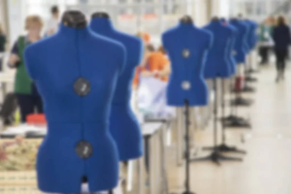 Blurred background with women are engaged in tailoring of tights in a factory