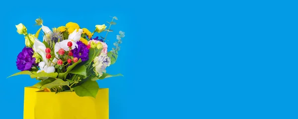 Hermosas tarjetas de felicitación para la fiesta 8 de marzo, Día de las Madres, Cumpleaños. Fondo azul con un ramo de flores en un paquete amarillo . — Foto de Stock