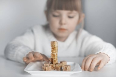Child, sugar cubes. The problem of excessive consumption of sugar by children. clipart