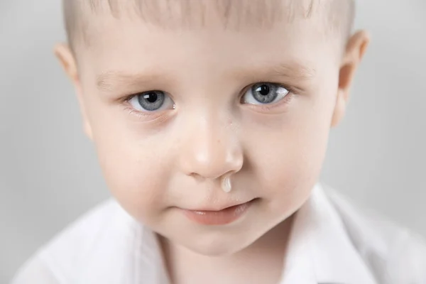 Niño tiene secreción nasal con mocos claros Imagen de archivo