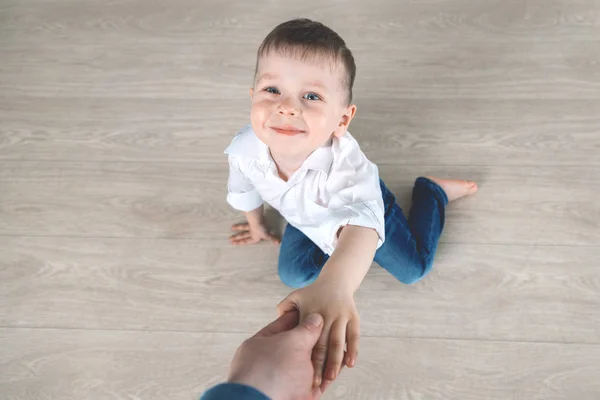 Papa hilft dem Kind, vom Boden aufzustehen. — Stockfoto