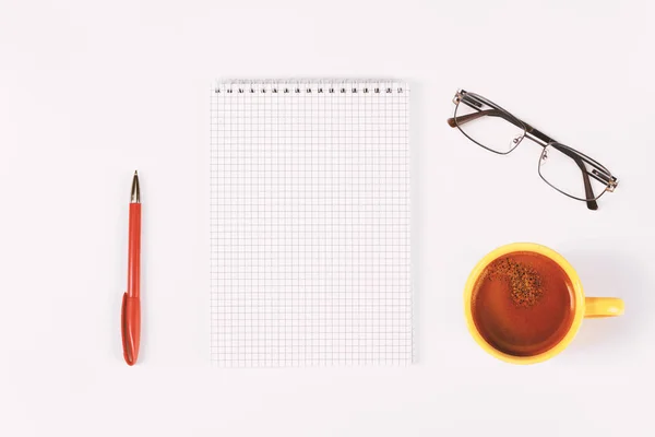 Prázdný deník, pero, šálek kávy a sklenice na bílém stole — Stock fotografie