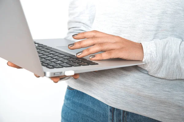 Jeune femme en vêtements décontractés tenant ordinateur portable — Photo