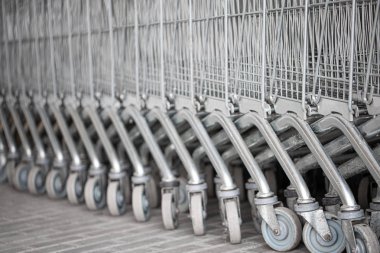 Alışveriş arabaları süpermarket yakınındaki sokakta üst üste düzenlenmiştir. Alışveriş sepetinin tekerleğini kapatın. Alışveriş konsepti.