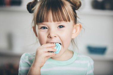 Tatlı küçük bir kız merengue yer.