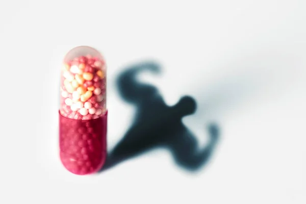 アナボリックカプセル – 男性の筋上体の形 – 医学薬物乱用のためのシンボル. — ストック写真