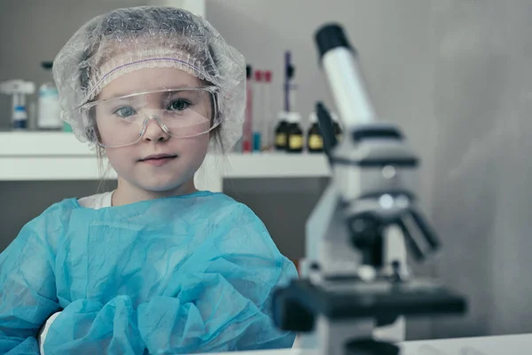 Little girl makes scientific experiments with chemical and biological products in her home laboratory. — Stock Photo, Image