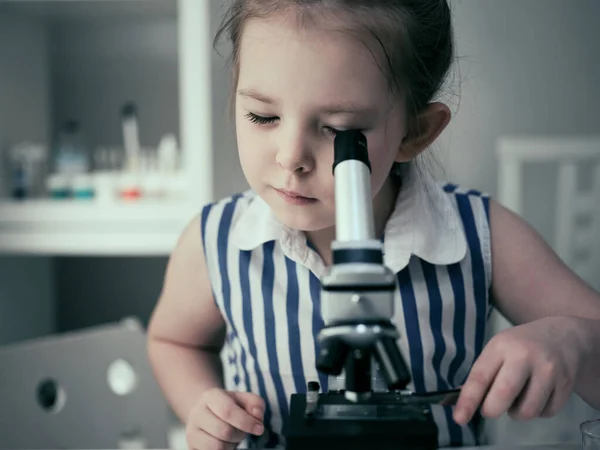 Dívka dělá vědecké experimenty s chemickými a biologickými produkty ve své domácí laboratoři. — Stock fotografie