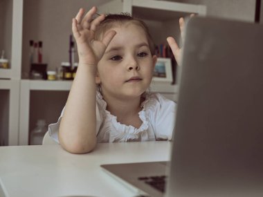 Evde dizüstü bilgisayar kullanan tatlı bir kız. Eğitim, çevrimiçi öğrenim, evde öğrenim Çocuk mesafesi öğrenimi