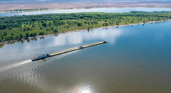 A barge or dry cargo ship goes upstream of the Volga River near Astrakhan. Aerial photography