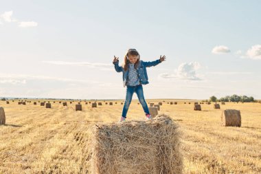 Sevimli küçük bir kız müzik dinler ve samanlıkta dans eder..
