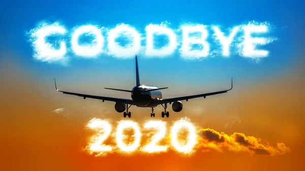 Un aereo che vola in lontananza. Iscrizione a forma di nuvola - GOODBYE 2020 — Foto Stock