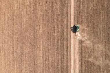 Havadan insansız hava aracı manzarası. Hasat alanında çalışan traktörün güzel sonbahar manzarası. Tarım kavramı.
