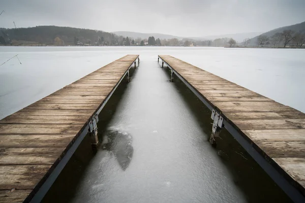 Bevroren meer met houten pier — Stockfoto