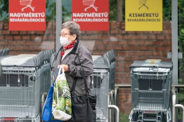 PECS - 27 Mayıs: 27 Mayıs 2020 tarihinde yaşlı kadın Pecs, Macaristan 'da alışverişe gider. Coronavirus salgını sırasında herkes maske takmak zorundadır.