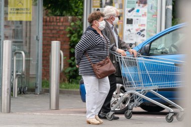 PECS - 27 Mayıs: 27 Mayıs 2020 tarihinde yaşlı kadın Pecs, Macaristan 'da alışverişe gider. Coronavirus salgını sırasında herkes maske takmak zorundadır.