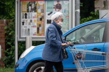 PECS - 27 Mayıs: 27 Mayıs 2020 tarihinde yaşlı kadın Pecs, Macaristan 'da alışverişe gider. Coronavirus salgını sırasında herkes maske takmak zorundadır.