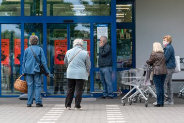 PECS - 27 Mayıs 2020 tarihinde Macaristan 'ın Pecs kentinde yaşlı insanlar alışverişe gider. Coronavirus salgını sırasında herkes maske takmak zorundadır.